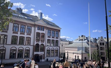 en gruppe mennesker som går foran en bygning