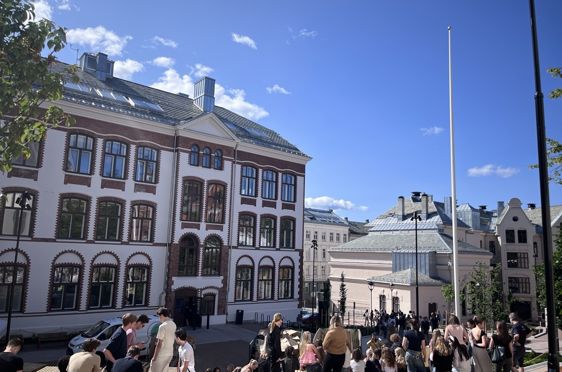 en gruppe mennesker som går foran en bygning