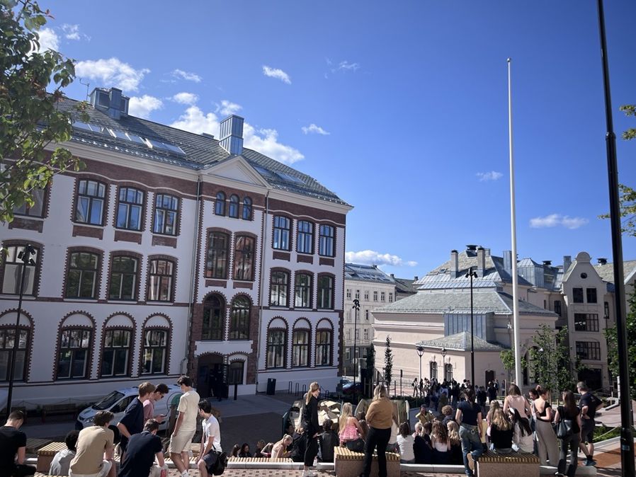 en gruppe mennesker som går foran en bygning